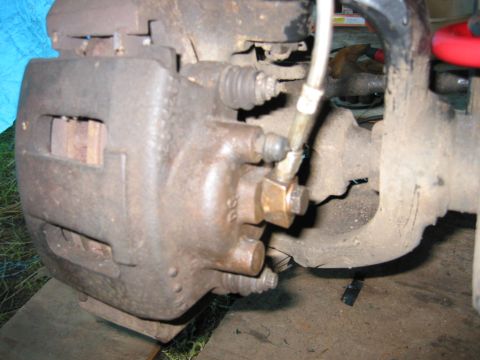 1991 Ford Explorer - This photo shows a close-up of a vehicle's brake caliper and associated components, with visible rust and wear.