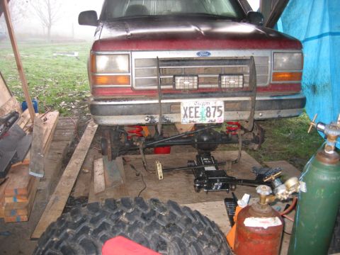 1991 Ford Explorer - The front end of a 1991 Ford Explorer is shown with its axle removed, indicating mechanical work is in progress.