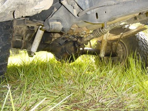 1989 Ford Bronco - The underside of a vehicle, focusing on the suspension and drivetrain components, is captured in this image.