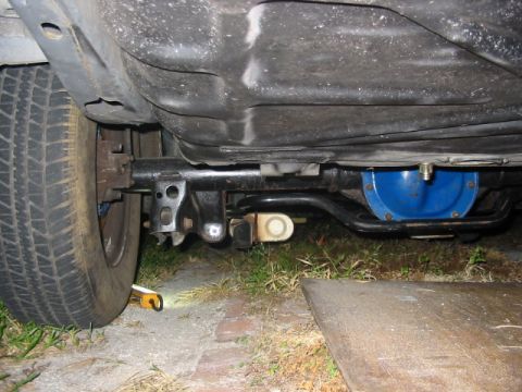 1985 Ford Crown Victoria LTD - Underside view of rear axle and suspension components, including a blue differential cover.