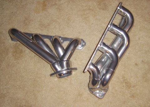 1986 Ford Bronco - Pair of chrome exhaust headers shown on a carpeted floor.