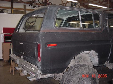1978 Ford Bronco - Rear view of a 1978 Ford Bronco in a garage, showing the quarter panel and bumper.