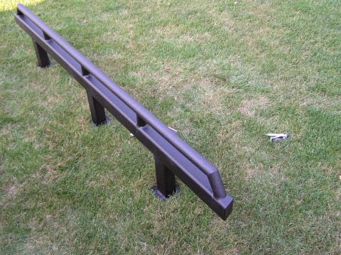 2000 Chevrolet Tahoe - Black metal step bars are shown installed on a grassy area.