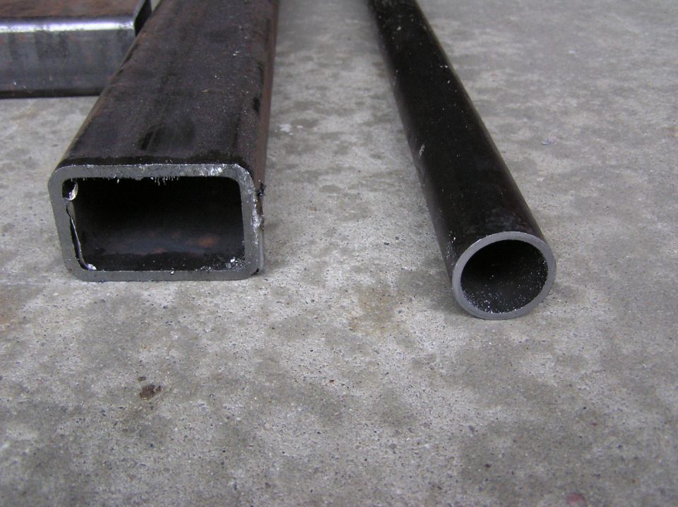 Close-up of square and round metal tubing on concrete