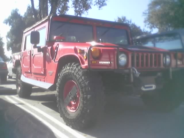 Red Hummer H1 front three-quarter view with large off-road tires