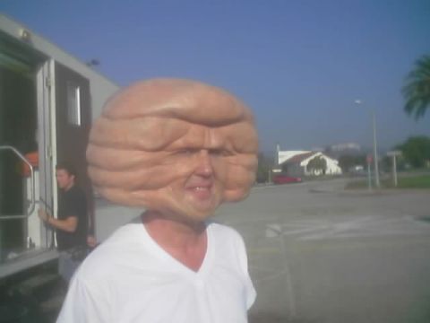 1968 Ford Mustang - A person is seen wearing a prosthetic head that resembles a large, wrinkled brain.