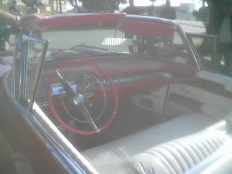 1968 Ford Mustang - Interior view of a vintage convertible, a red steering wheel and white upholstery.