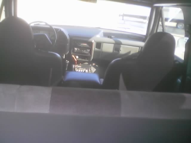 View of a truck dashboard and front seats from the rear cargo area