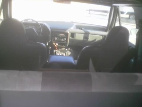 1990 Ford Bronco - View of a vehicle's dashboard, gauges, center console and dark front bucket seats seen over the rear cargo area divider.