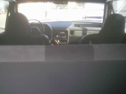 1990 Ford Bronco - dashboard, steering wheel and front seats of a truck or SUV viewed from behind, with the cargo area divider in the foreground.