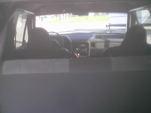 Truck interior dashboard and seats with a green field visible through the windshield