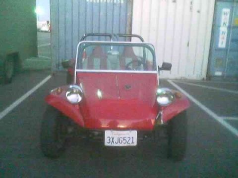 1990 Ford Bronco - red dune buggy with chrome headlights and roll cage parked head-on, showing a California license plate reading 3XJG521.