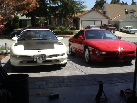 1997 Ford Probe - Two 1997 Ford Probes are visible in this image, one white with a contrasting black hood and the other in red.