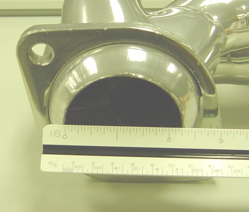 Close-up of a metal exhaust header pipe with a ruler measuring its diameter