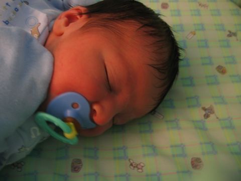 2002 Ford Taurus - A baby sleeps peacefully with a blue pacifier in its mouth, wrapped in a light blue blanket.