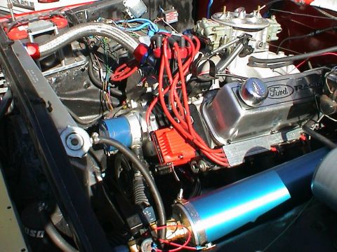 1979 Ford Bronco - Close-up of a modified Ford V8 engine, likely for racing, showing custom valve covers and ignition system.