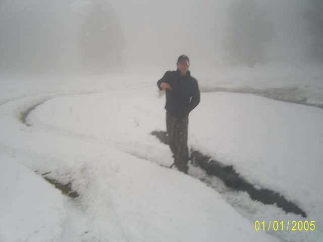 Person standing in snow on a foggy day, no vehicle visible