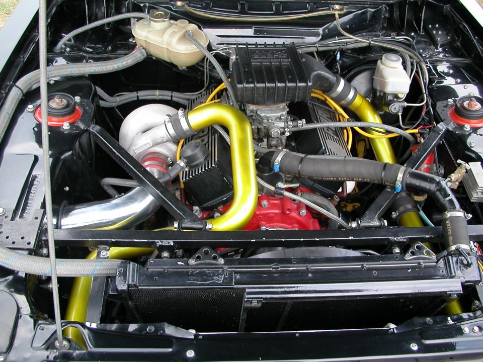Engine bay with turbocharger, yellow intake piping, and red engine block