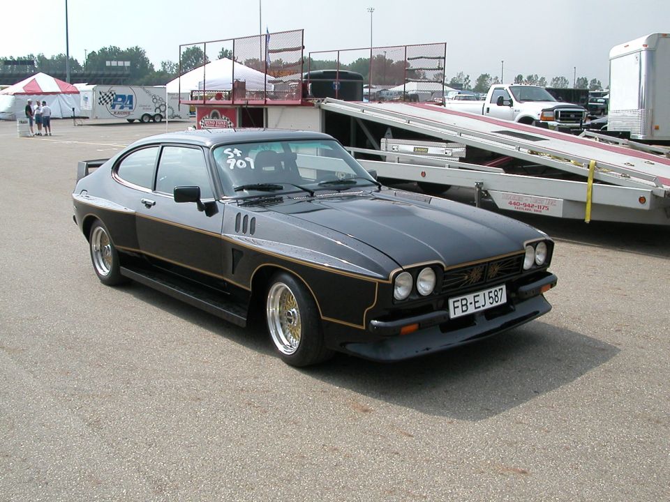 Black coupe with gold trim and gold wheels, front license plate FB-EJ587