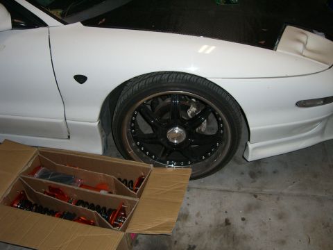 1996 Ford Probe - A 1996 Ford Probe's side profile shows a custom wheel and a box of new suspension parts.