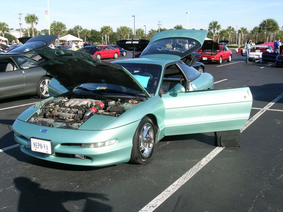 mint green Ford Probe with hood and door open, parked in lot with other cars