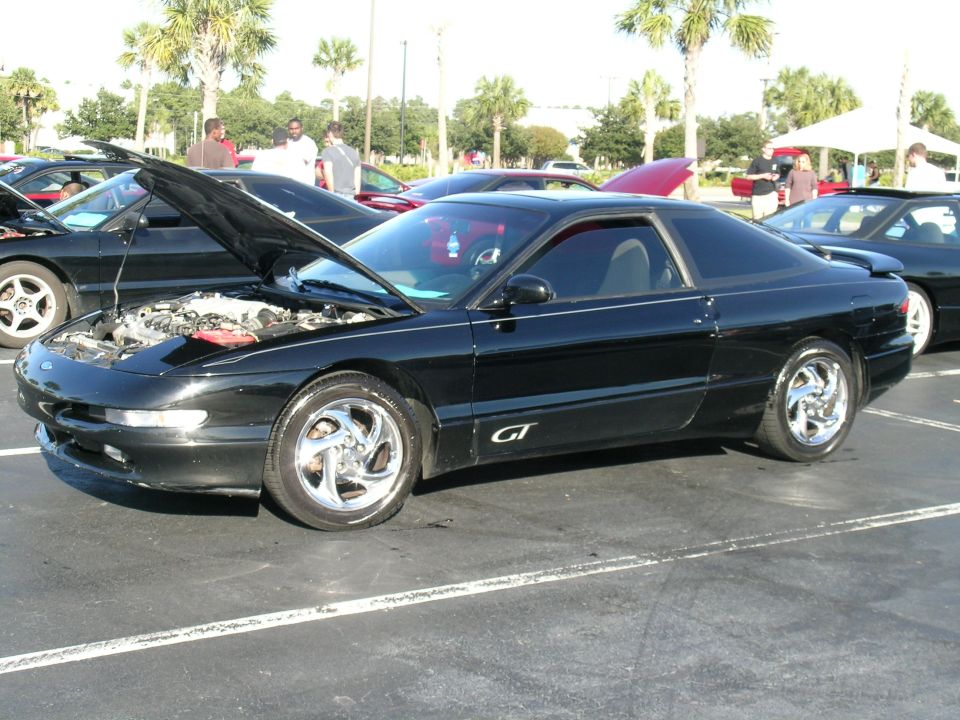 Black Ford Probe GT with hood open, parked in a lot with other cars