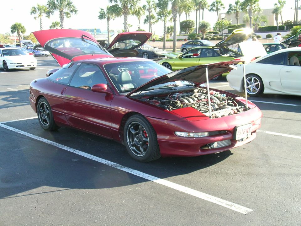 Red 1993 Ford Probe coupe with hood and trunk open, parked in a lot