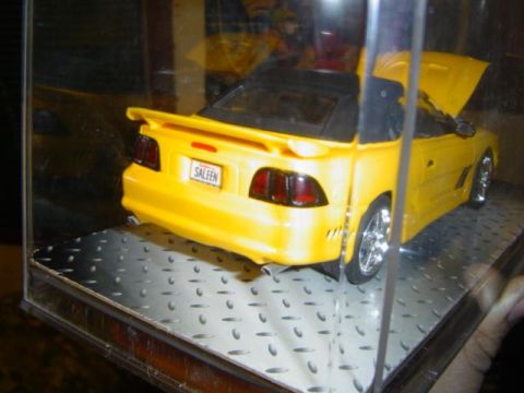 1979 Ford Bronco - A yellow convertible model car with a 'SALEEN' license plate is displayed with its hood open.