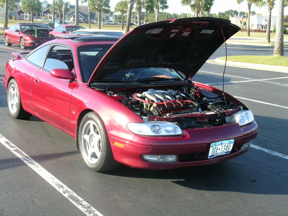Red coupe with hood open, revealing engine. License plate reads 004-1340