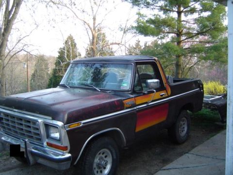 1979 Ford Bronco - This 1978 Ford Bronco shows its age with faded paint and a prominent stripe along the side.