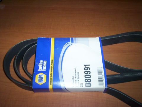1998 Ford Crown Victoria - coiled NAPA Belts/Hose premium V-ribbed serpentine belt, part number 080991, resting on a wooden surface.