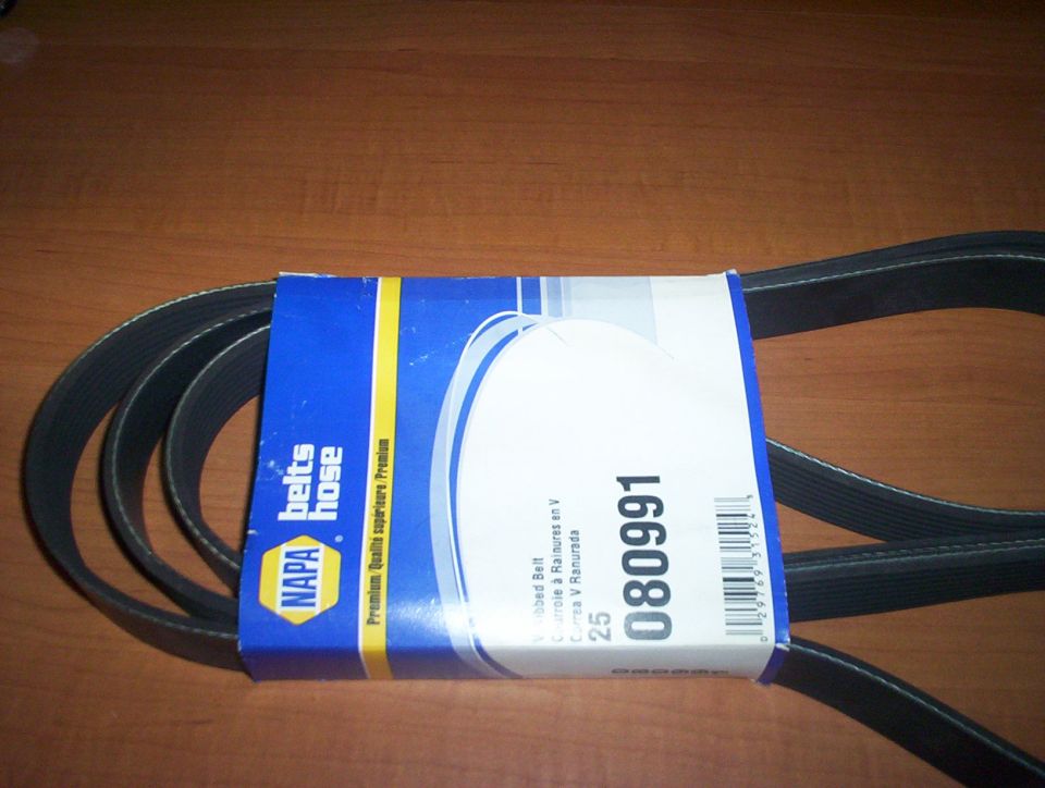 NAPA Belts/Hose serpentine V-ribbed belt number 080991 coiled on a wood table