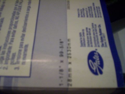 1998 Ford Crown Victoria - Out-of-focus photo of a Gates product box label with belt dimensions, too blurry to classify as a document.