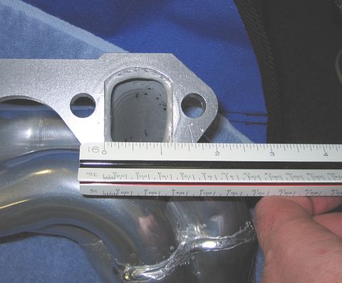1986 Ford Bronco - Exhaust manifold part being measured with a ruler. The album claims it is from a 1986 Ford Bronco.