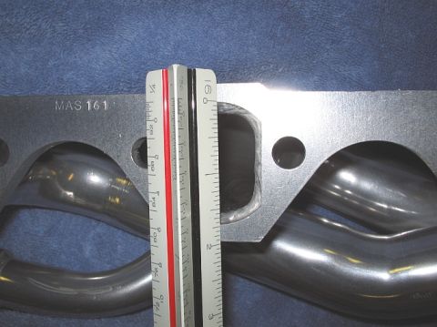 1986 Ford Bronco - An exhaust manifold is shown with a ruler for scale, indicating its dimensions.