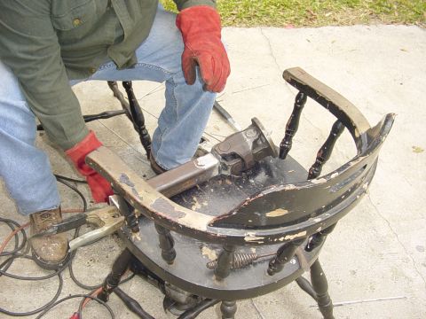 1989 Ford Bronco - A driveshaft component is being worked on while clamped to a chair, with welding equipment nearby.