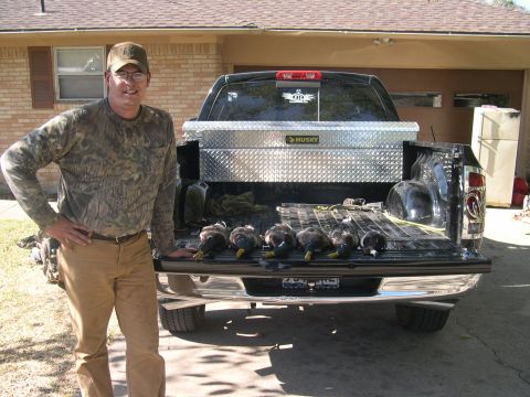 1992 Ford Bronco - A hunter poses with his retrieved ducks in the bed of his pickup truck.