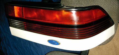 1992 Ford Probe - A single taillight assembly, a blue Ford emblem, is shown against a dark background.