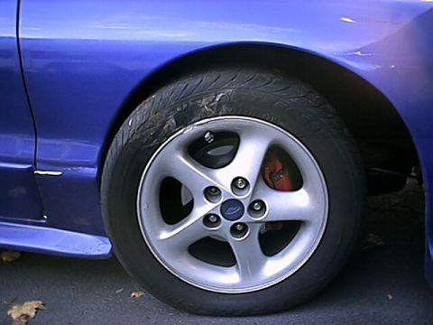 1993 Ford Probe - A close-up view of the front wheel and fender of a blue 1993 Ford Probe.
