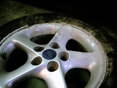 1993 Ford Probe - A close-up view of a silver alloy wheel with a visible Ford emblem in the center hub.