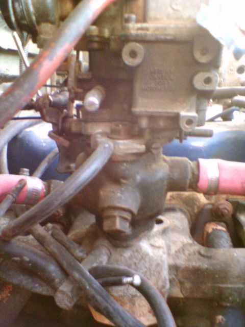 1985 Ford F-150 - Engine bay detail showing a carburetor and associated plumbing.