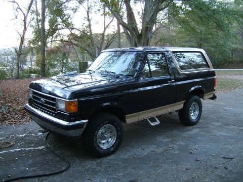 1988 Ford Bronco - This black Ford Bronco, likely a 1987 model, is shown from a three-quarter front angle.