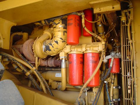 1966 International School Bus - Close-up view of a yellow engine compartment multiple red oil filters and a turbocharger.