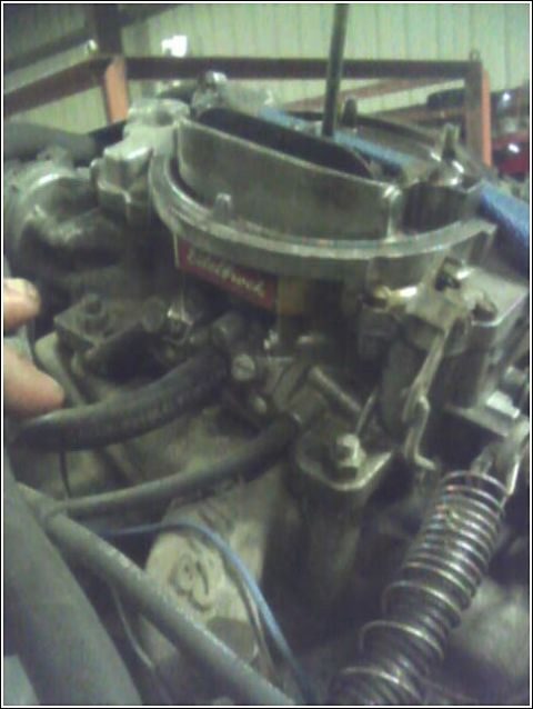 1980 Ford Bronco - A close-up view of a vehicle's carburetor, showing various mechanical components and hoses.