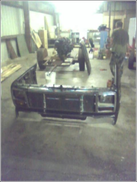 1980 Ford Bronco - Front clip and chassis of a 1980 Ford Bronco with engine visible in the background.