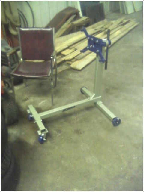 1980 Ford Bronco - An engine stand and a chair are set up in a garage, with lumber stacked behind them.
