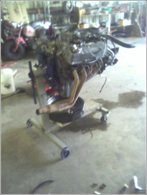 1980 Ford Bronco - An engine is mounted on a stand, possibly for repair or replacement, in a workshop setting.