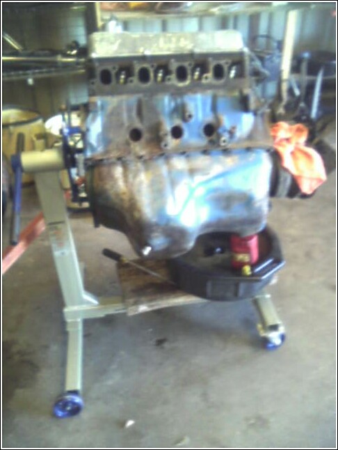 Engine block on a stand with an oil drain pan underneath