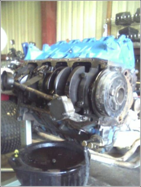 1980 Ford Bronco - Engine assembly with blue protective covering and an oil drain pan.