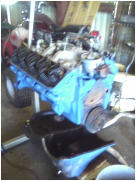 1980 Ford Bronco - Engine block painted blue sits above an oil pan, likely during a repair or rebuild process.
